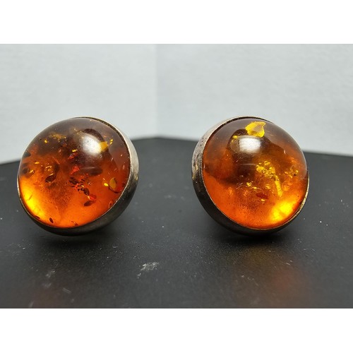 212 - A pair of pretty 925 silver large stud earrings inset with natural Baltic amber stones presenting a ... 