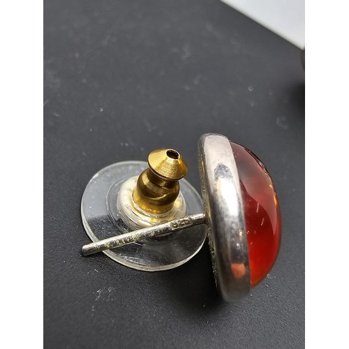 212 - A pair of pretty 925 silver large stud earrings inset with natural Baltic amber stones presenting a ... 