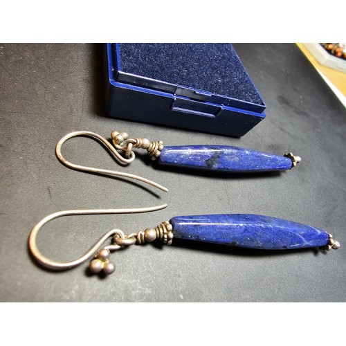 208 - A pair of tested as sterling silver long drop earrings featuring faceted sodalite stones, in good cl... 