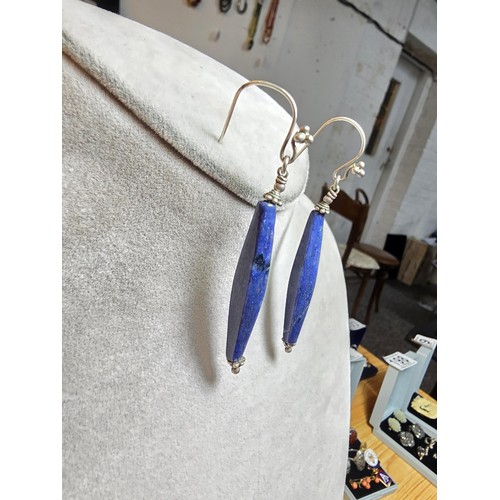 208 - A pair of tested as sterling silver long drop earrings featuring faceted sodalite stones, in good cl... 