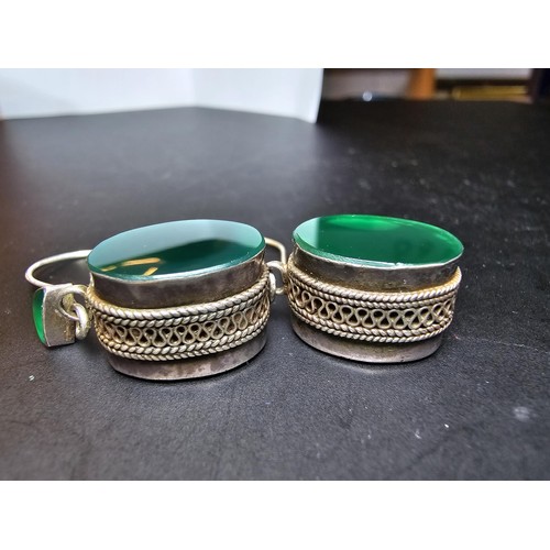 207 - A pair of large ornate and unusual sterling silver drop earrings featuring a polished green glass in... 