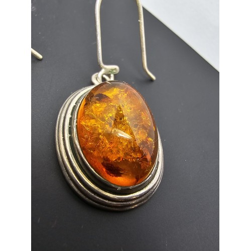 203 - A large good quality 925 silver pair of amber earrings inset wit large natural Baltic amber cabochon... 