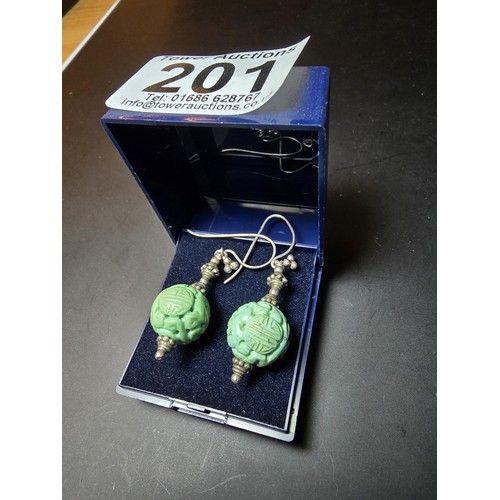 201 - An ornate vintage pair tested as sterling silver drop earrings featuring carved green turquoise ston... 