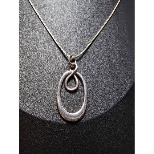 223 - A 925 silver pendant with a hoop and figure of eight design set on a 18