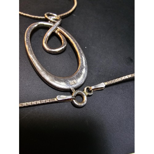 223 - A 925 silver pendant with a hoop and figure of eight design set on a 18