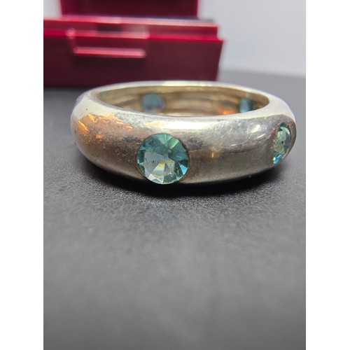 220 - A chunky 925 silver ring inset with faceted blue crystal CZ stones all the way around. In good clean... 