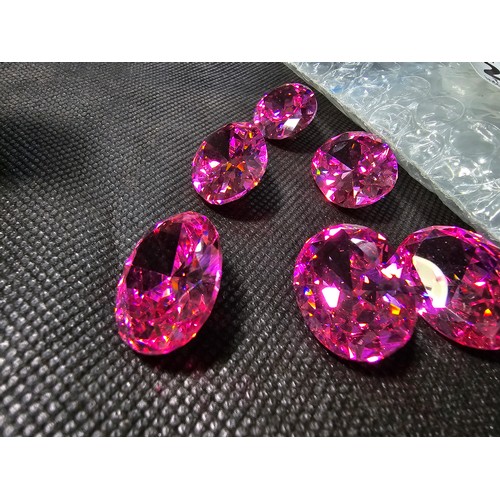 233 - A large collection of 6x large pink faceted crystal glass stones which are imitation sapphires. The ... 