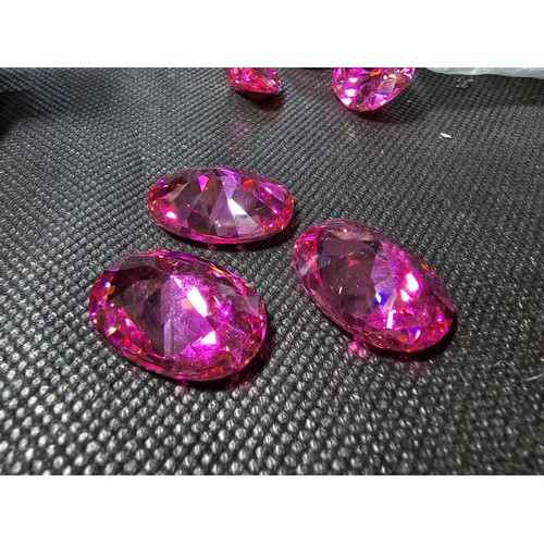 233 - A large collection of 6x large pink faceted crystal glass stones which are imitation sapphires. The ... 