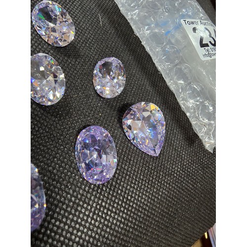 234 - A large collection of 10x large faceted crystal glass stones which are imitation sapphires. To inclu... 