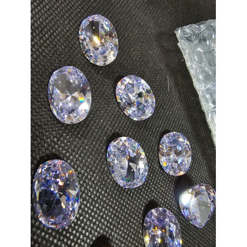 234 - A large collection of 10x large faceted crystal glass stones which are imitation sapphires. To inclu... 