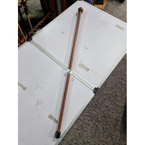 3 - A solid wood walking stick with a carved round top, in good overall condition.