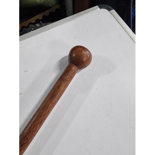 3 - A solid wood walking stick with a carved round top, in good overall condition.