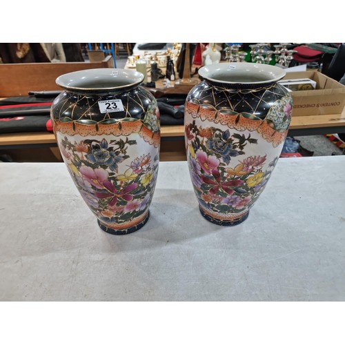 23 - Pair of tall hand decorated ceramic vases with floral design both in good order with no chips or cra... 