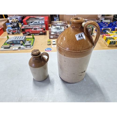 44 - 2x earthenware flagons inc a small flagon with cross topped stopper and a tall flagon both in overal... 