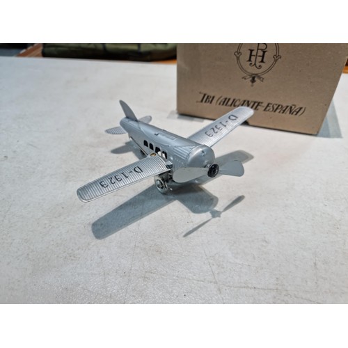 65 - Boxed tin plate reproduction of a clock work plane with fold back wings, based on a plane from 1927,... 