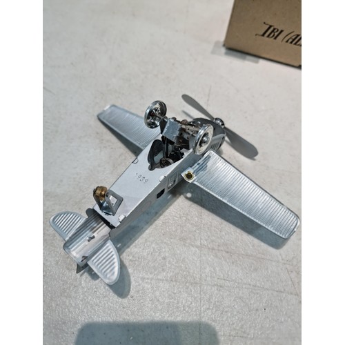 65 - Boxed tin plate reproduction of a clock work plane with fold back wings, based on a plane from 1927,... 