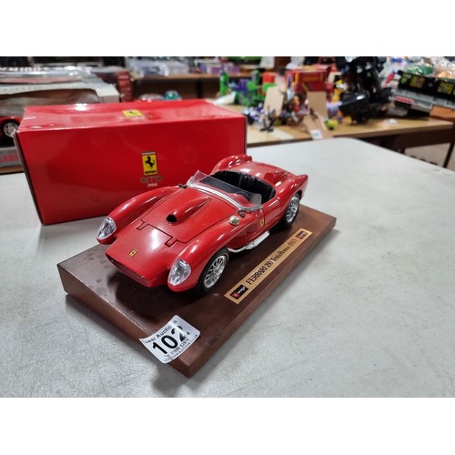 102 - A collection of 2 diecast boxed cars including a Burago Ferrari GTO 1984 on a wooden plinth along wi... 
