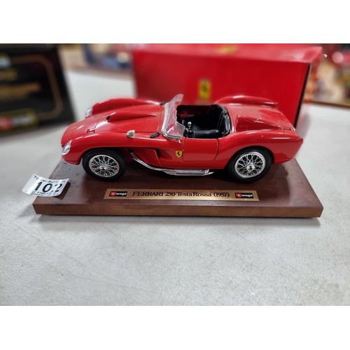 102 - A collection of 2 diecast boxed cars including a Burago Ferrari GTO 1984 on a wooden plinth along wi... 