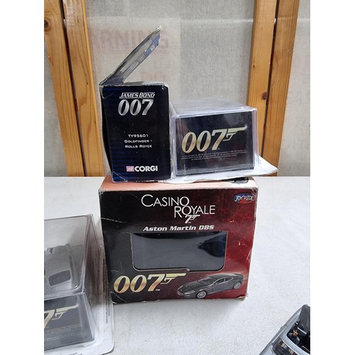 68 - A collection of James Bond related diecast vehicles to include 2x loose Corgi Aston Martin DB5's of ... 