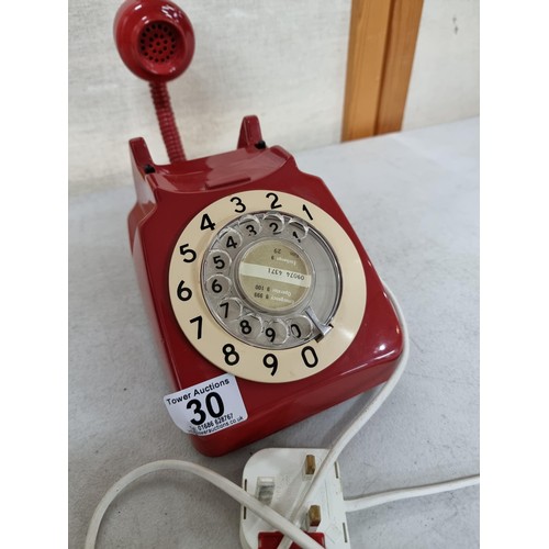 30 - A converted vintage red rotary dial telephone stamped P.O. Authorized release 701 underneath (tele 8... 