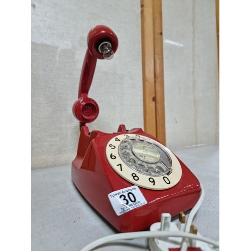 30 - A converted vintage red rotary dial telephone stamped P.O. Authorized release 701 underneath (tele 8... 