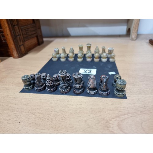 22 - A miniature set  of resin chess pieces, all  individually carved with good detailing, tallest has a ... 