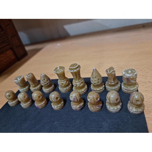 22 - A miniature set  of resin chess pieces, all  individually carved with good detailing, tallest has a ... 