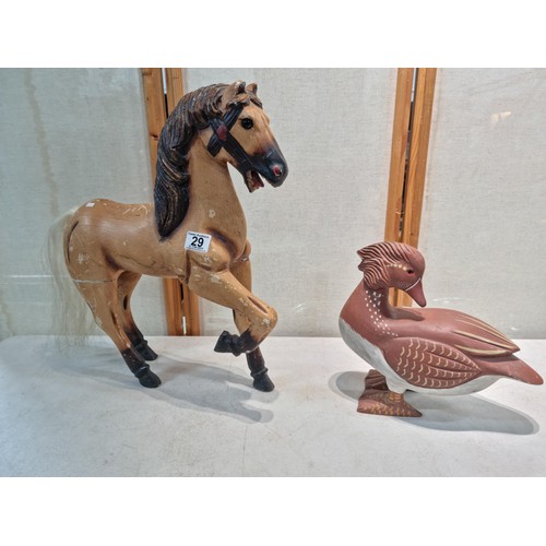 29 - A large wooden horse figure in a prancing stance along with a large wooden duck figure. Both of the ... 