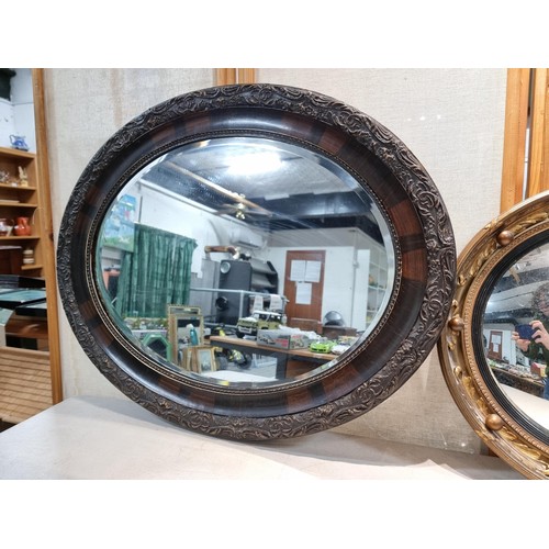 40 - 2 ornate mirrors, 1 in an oval frame with a carved edge and bevel edged along with a port hole mirro... 