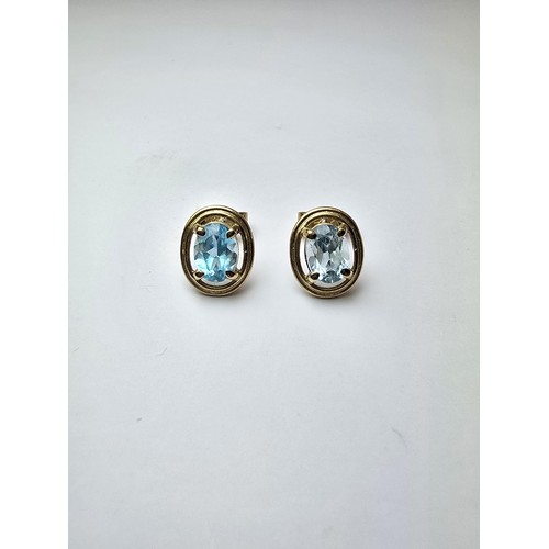 289 - A pair of stunning hallmarked 9ct yellow gold stud earrings inset with large faceted natural blue sp... 