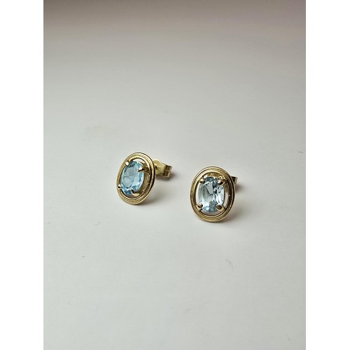 289 - A pair of stunning hallmarked 9ct yellow gold stud earrings inset with large faceted natural blue sp... 