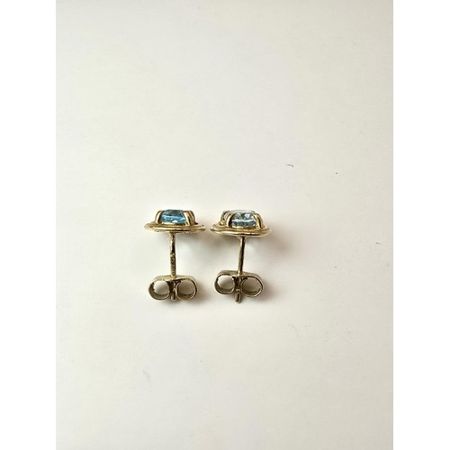 289 - A pair of stunning hallmarked 9ct yellow gold stud earrings inset with large faceted natural blue sp... 