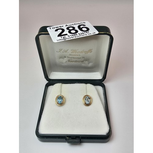 289 - A pair of stunning hallmarked 9ct yellow gold stud earrings inset with large faceted natural blue sp... 