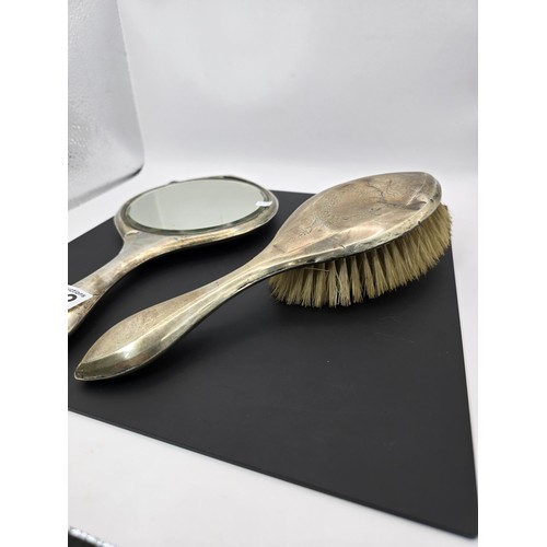 272 - An antique heavy duty hallmarked silver backed dressing table mirror and brush having an engraved de... 