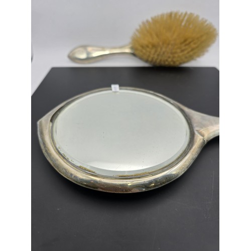 272 - An antique heavy duty hallmarked silver backed dressing table mirror and brush having an engraved de... 