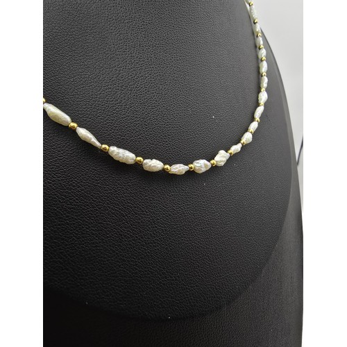 273 - A hallmarked 9ct yellow gold and natural pearl beaded necklace featuring pearl beads and 9ct gold be... 