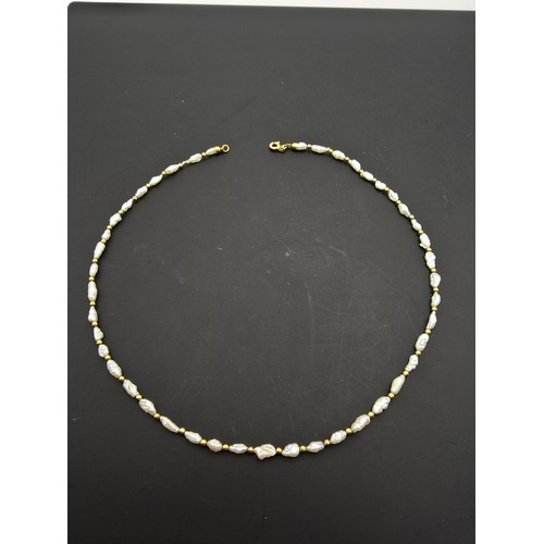 273 - A hallmarked 9ct yellow gold and natural pearl beaded necklace featuring pearl beads and 9ct gold be... 