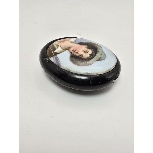 274 - An antique Victorian Whitby jet mounted hand painted plaque of a portrait of a boy name urchin boy, ... 