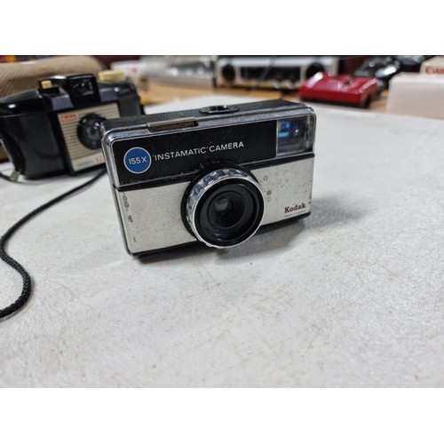 4 - Shelf containing a collection of cameras inc a Brownie 127, 2x Kodak Instamatic cameras, red Haminex... 