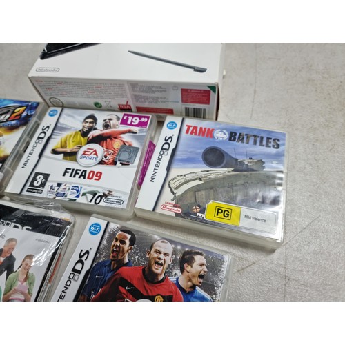 15 - A boxed Nintendo DS lite in black and grey along with its charger along with 4 boxed games.