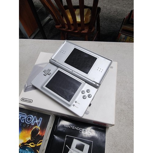 17 - A boxed Nintendo DS lite in silver complete with charger,included 4 boxed games. including Mario Par... 