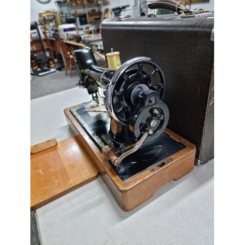 27 - A cased Singer manual sewing machine No: EG818354 with a quantity of accessories in a fitted case.