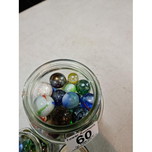 60 - 2x jars containing a large quantity of collectable marbles inc a large quantity of blue yellow and w... 