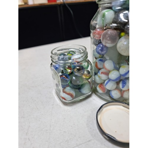 60 - 2x jars containing a large quantity of collectable marbles inc a large quantity of blue yellow and w... 