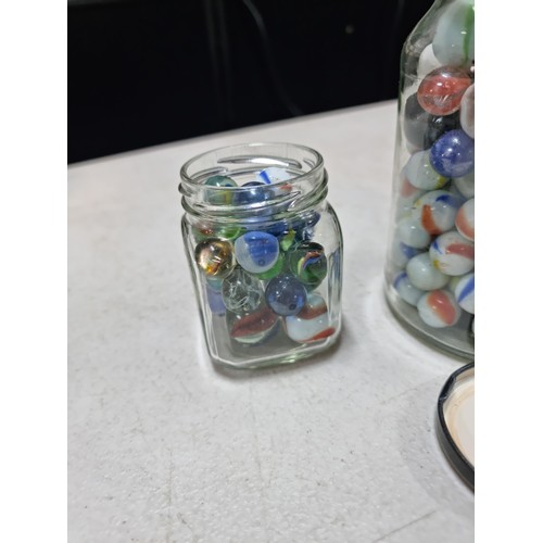 60 - 2x jars containing a large quantity of collectable marbles inc a large quantity of blue yellow and w... 