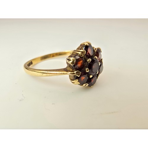 249 - A vintage hallmarked 9ct yellow gold garnet cluster ring featuring 7 faceted garnet gemstones which ... 