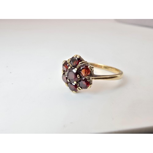 249 - A vintage hallmarked 9ct yellow gold garnet cluster ring featuring 7 faceted garnet gemstones which ... 