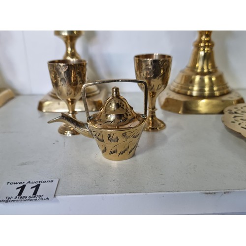 11 - A quantity of brass ware including a pair of good quality The diamond Prince candlesticks along with... 