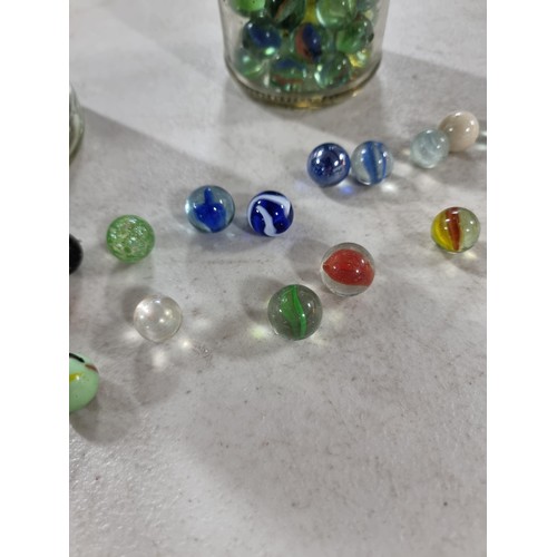 49 - 2x Jars of marbles of various designs inc iridescent marbles, green and white marbles etc, please se... 