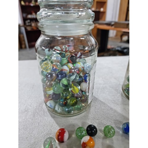 49 - 2x Jars of marbles of various designs inc iridescent marbles, green and white marbles etc, please se... 